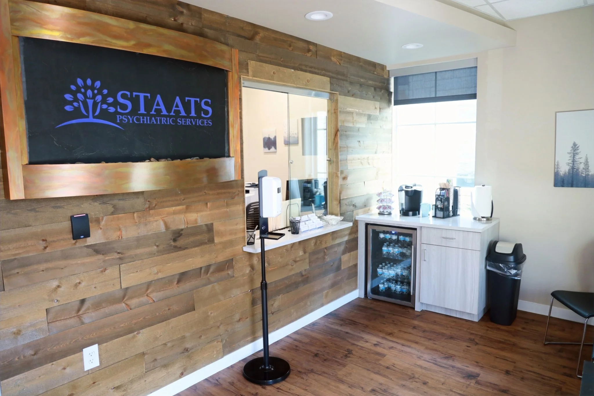 Staats Psychiatric Services reception area with wooden accent wall, illuminated logo, and check-in desk